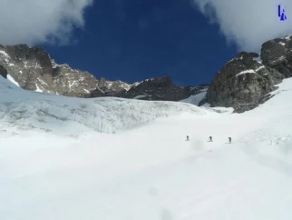 Pred začetkom tega ledenika (Glacier de l'Ailefroide) dva člana spoznata pomanjkljivosti srenačev. No ubistvu prednosti tega, da jih nimaš. Na kratko: če nimaš srenačev, se prej preobuješ v dereze in potem ni možnosti, da s smučkami (ker imaš srenače) zdrsneš na strmem pobočju.