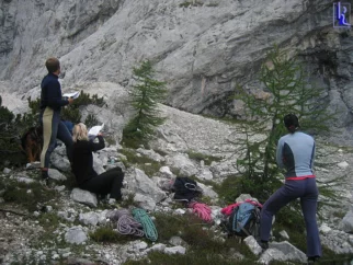 Kmalu smo pod steno. Ugotovimo, da je kar gneča. Odločimo se, da gremo Kuštrasto (V/IV).